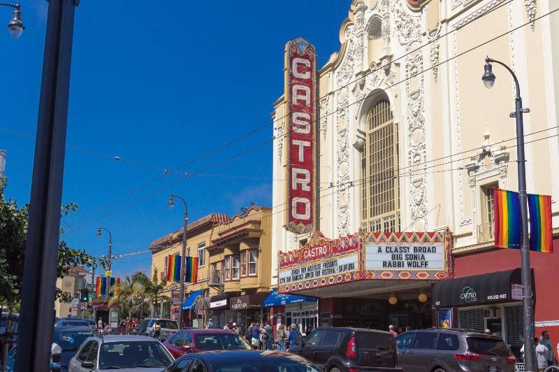 Castro Theatre in San Francisco with rainbow flags along the street.